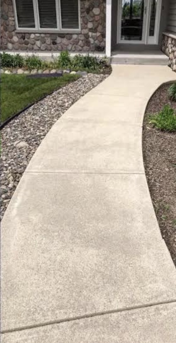 The same curved walkway restored to a clean, light finish after pressure washing