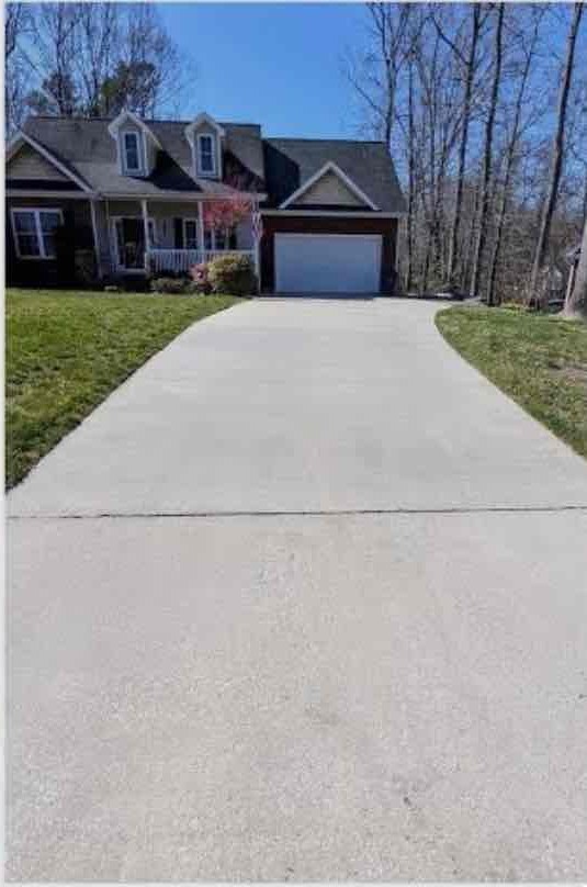 The same concrete driveway clean and bright after pressure washing